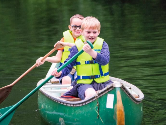 Two boys canoeing on the lake