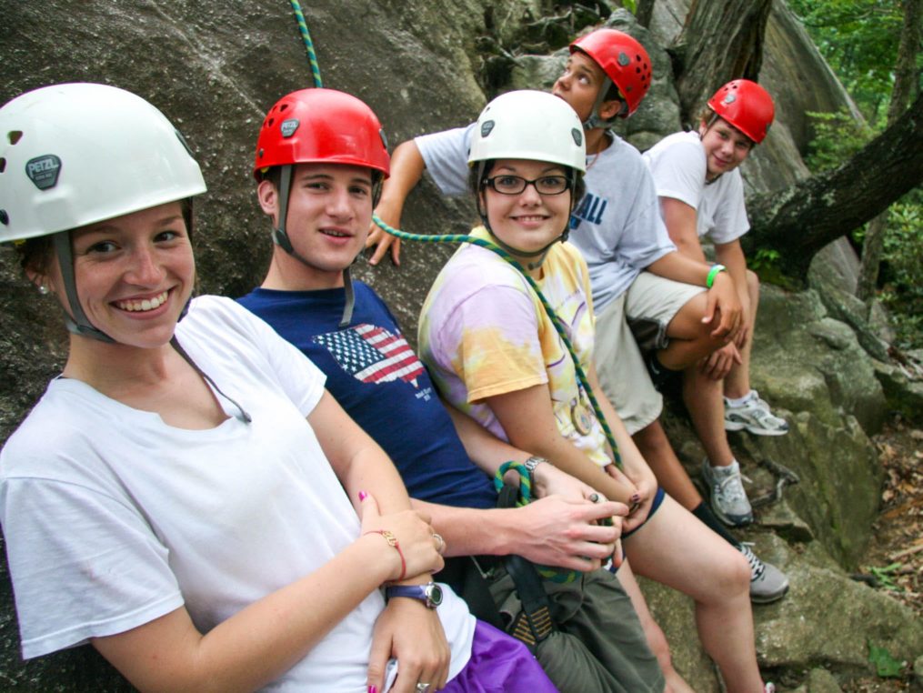 Group of teen climbers standing by rock wall on the Rock Climbing & Canoeing Pioneer Expedition