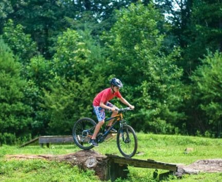 Pioneer biking over an obstacle on an Expedition trip