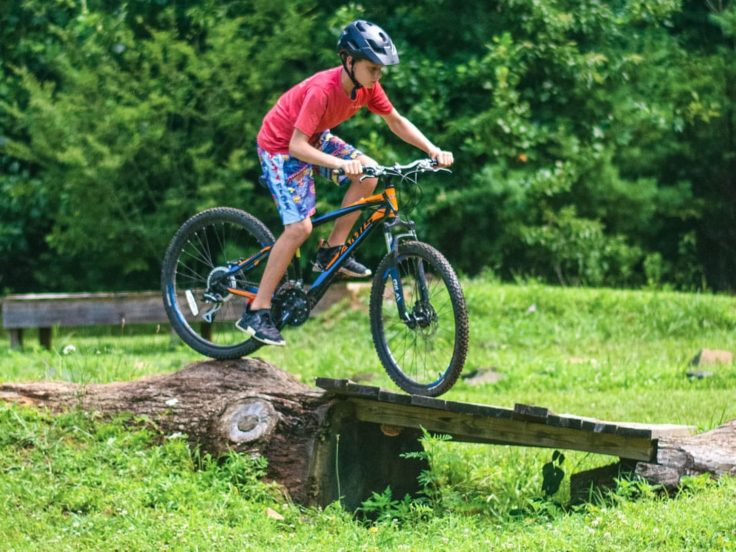 Boy mountain biking over bridge